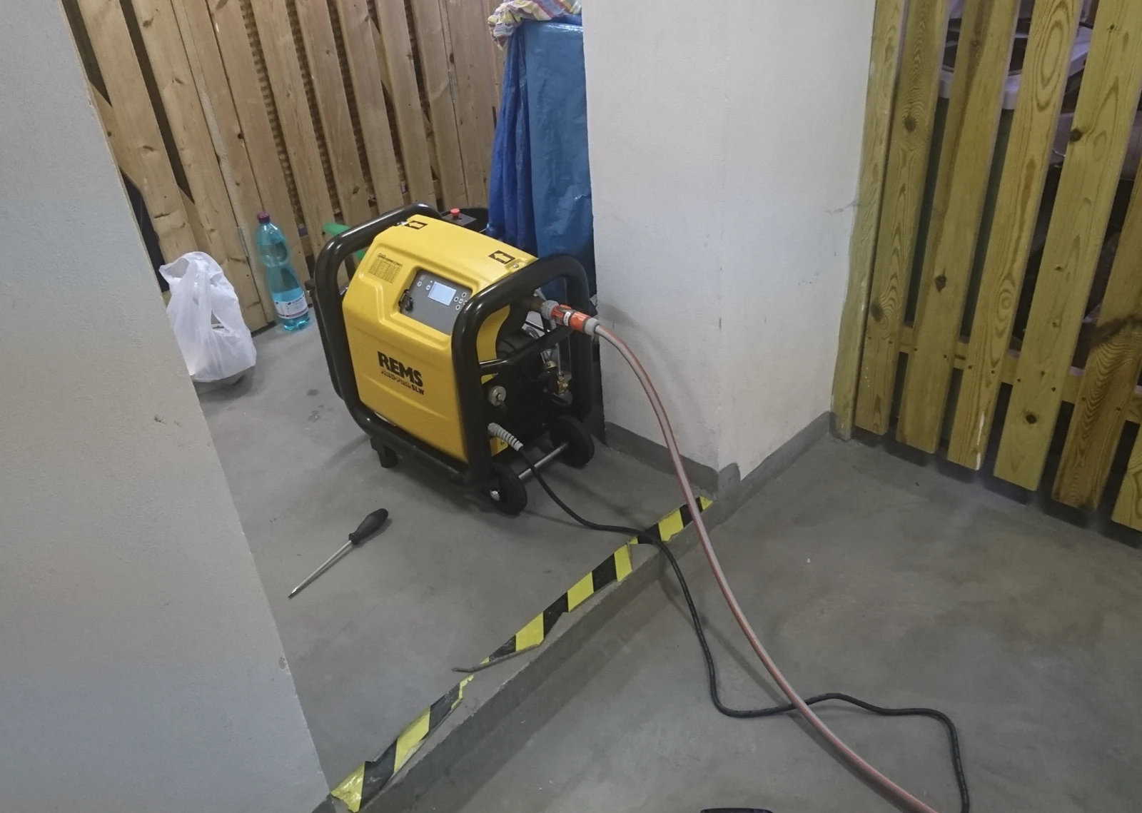 REMS Multi-Push SLW připojený hadicemi při skutečném čištění topení
